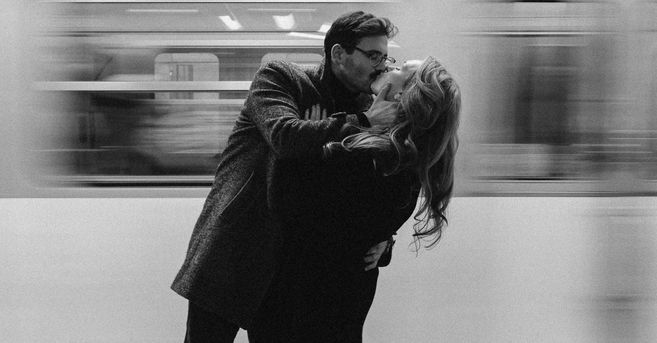 Josh and Erin kissing in front of subway train